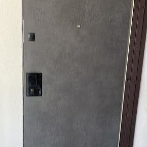 דלת אפורה עם ציפוי מתכתי ומנעול שחור