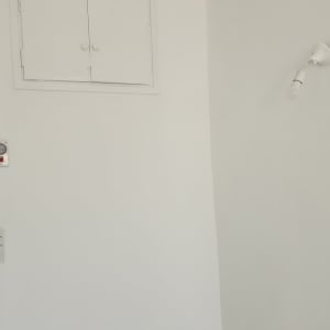 קיר צבוע בלבן עם מנורה ותקרה