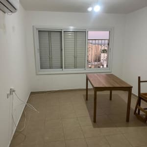 חדר ריק עם שולחן וכיסא, חלון ומזגן