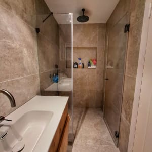 מקלחת עם ראש גשם ומדף עם מוצרי רחצה