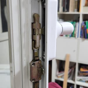 מנגנון נעילה של חלון או דלת עם ידית לבנה