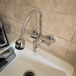 ברז נירוסטה מעל כיור מטבח עם קרמיקה