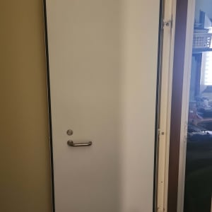 דלת לבנה עם ידית מתכת בחדר פנימי