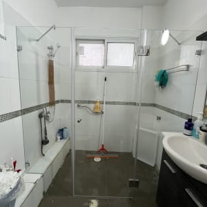 מקלחת עם דלת זכוכית וכלים לניקוי