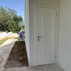 דלת לבנה עם ידית מתכת על קיר חיצוני