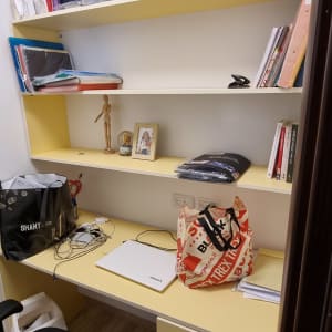 מדף עם בובת עץ של נגר על מדף צהוב