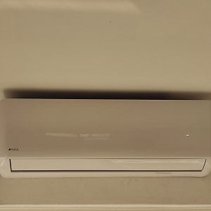 מזגן קיר לבן מותקן על קיר פנימי