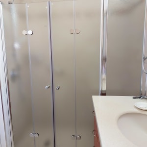 מקלחון זכוכית בחדר אמבטיה עם כיור