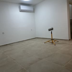 חדר עם רצפה מרוצפת ומזגן על הקיר
