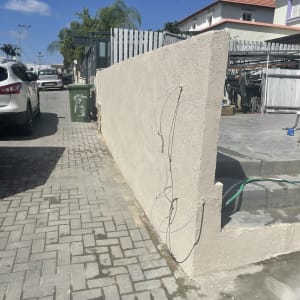 קיר בטון עם חוטים חשמליים חשופים בחוץ