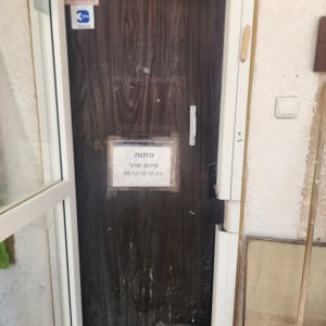 דלת עץ כהה עם שלט "פתוח"