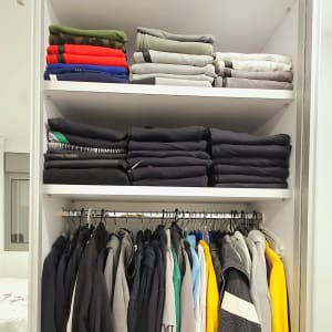 ארון בגדים מסודר עם חולצות מקופלות ותלויות