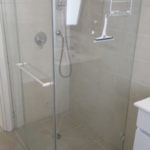 מקלחון זכוכית עם מדפים ומגב