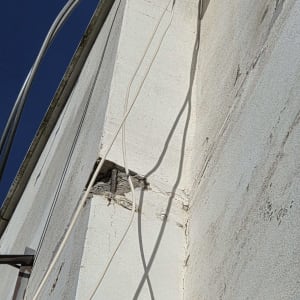 פגיעה ונזק לבטון ולטיח בחזית בניין בגובה לפני שיקום