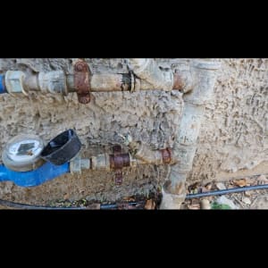 צינורות מים וחיבורים חלודים על קיר חיצוני