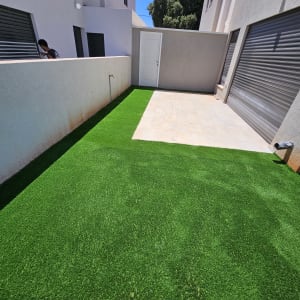 דשא סינתטי ירוק בחצר מרוצפת