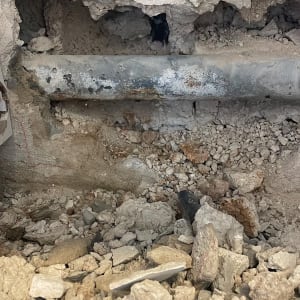 צינור חשוף בקיר עם אבנים מסביב