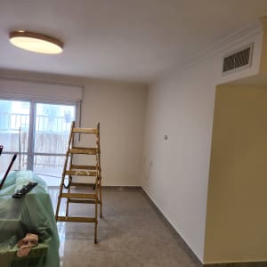 סולם וחומרי צביעה בחדר ריק עם קירות צבועים