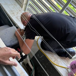 טכנאי עובד על מזגן עם צינורות וכלים