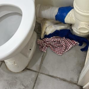 אסלה עם צינור דולף ומטליות על הרצפה