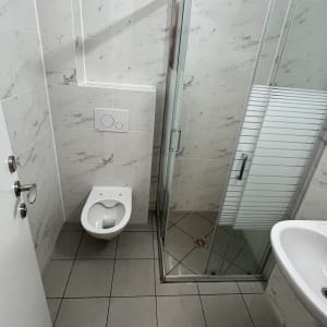 חדר אמבטיה נקי עם מקלחת ושירותים