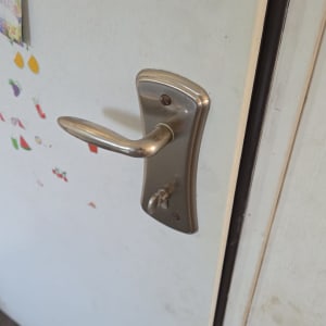 ידית דלת מתכת על דלת לבנה