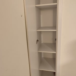 ארון לבן עם מדפים ודלת פתוחה