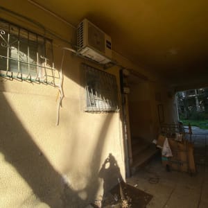 יחידת מזגן מותקנת על קיר חיצוני עם צינורות