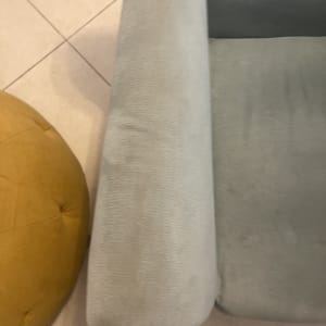 ספה אפורה עם כתמים על משענת היד