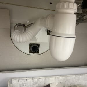 צינור ניקוז לבן מתחת לכיור עם חיבורים