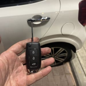 מפתח רכב עם שלט ליד דלת רכב לבנה