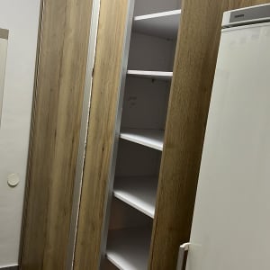 ארון עץ עם דלתות הזזה פתוחות ומדפים פנימיים