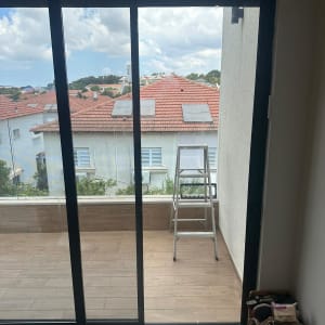 דלת זכוכית גדולה עם נוף לגינה ולסולם בחוץ