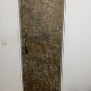 דלת מתכת עם ידית שחורה על קיר לבן