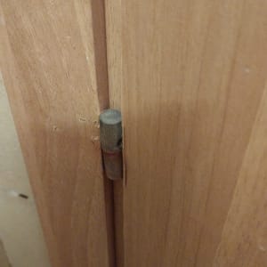 ציר מתכת בדלת עץ חומה