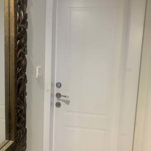 דלת לבנה עם ידית כסופה ומנעול עגול