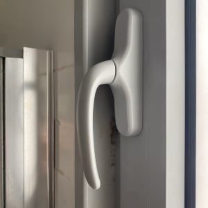 ידית תריס מתכתית על מסגרת חלון