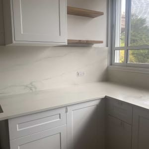 מטבח עם משטח שיש לבן ודוגמת עורקים אפורה