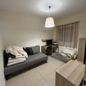 חדר עם ספה, שולחן מחשב ומנורה תלויה