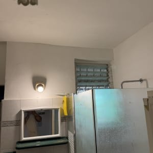 מבט על חדר רחצה עם מקלחון, מראה וחיפוי קרמיקה