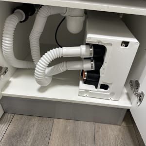 צנרת מתחת לכיור עם חיבורים לבנים וגמישים