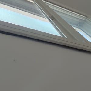 חלון אלומיניום פתוח עם מסגרת לבנה