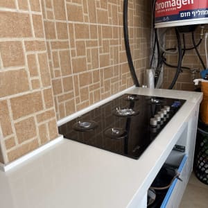 כיריים על משטח עבודה עם רקע קיר מרוצף