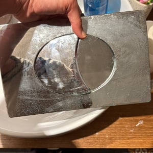 יד מחזיקה לוח מתכת ליד כיור ואביזרים