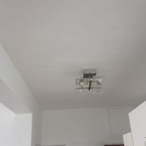 תקרה צבועה בלבן עם גוף תאורה מודרני