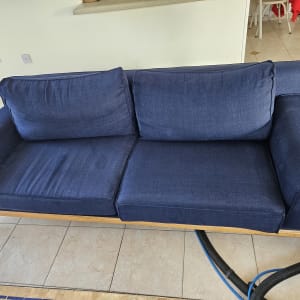 ספה כחולה עם צינורות ניקוי על הרצפה