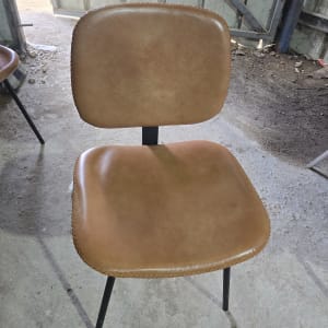 כיסא מרופד בעור חום עם רגליים שחורות