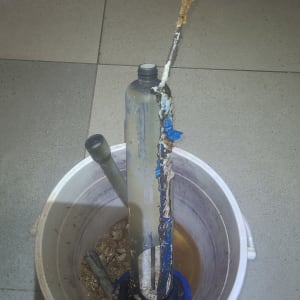 חלקי דוד שמש בתוך דלי על רצפה אפורה