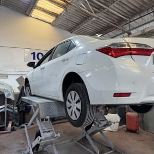 רכב לבן על מעלית במוסך לתיקון רכב