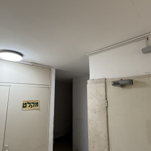 גוף תאורה עגול צמוד תקרה מותקן במבואת חדר מדרגות
